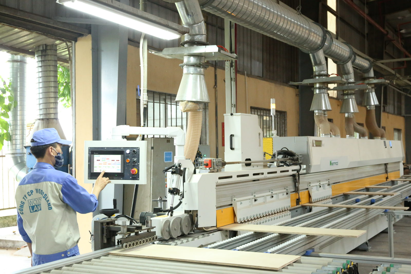 Woodsland factory floor — CNC edgebanding machine and technician